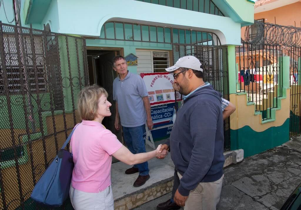 The Rev. Joan Kilian is greeted by Padre Hipólito Fernández Reyna at the entrance to El Buen Samaritano, a day care center in San Francisco de Marcorís. Mission team member Fred Richter is in the background of this photograph.